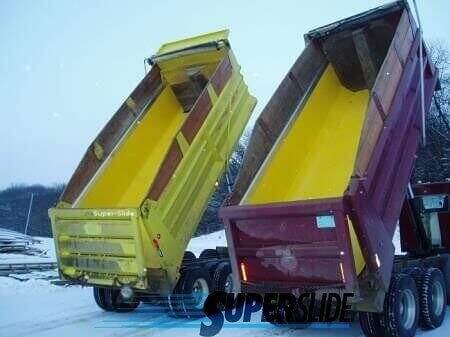 Two large dump trucks with yellow and red beds are tilted upward, showing off Super-Slide Yellow Quartz UHMW Liners. They’re parked on snow with trees behind them, and “SUPERSLIDE” is visible in the image.
